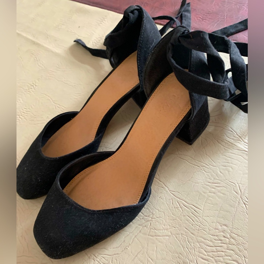 Black suede heel shoes with ribbon tied around ankle